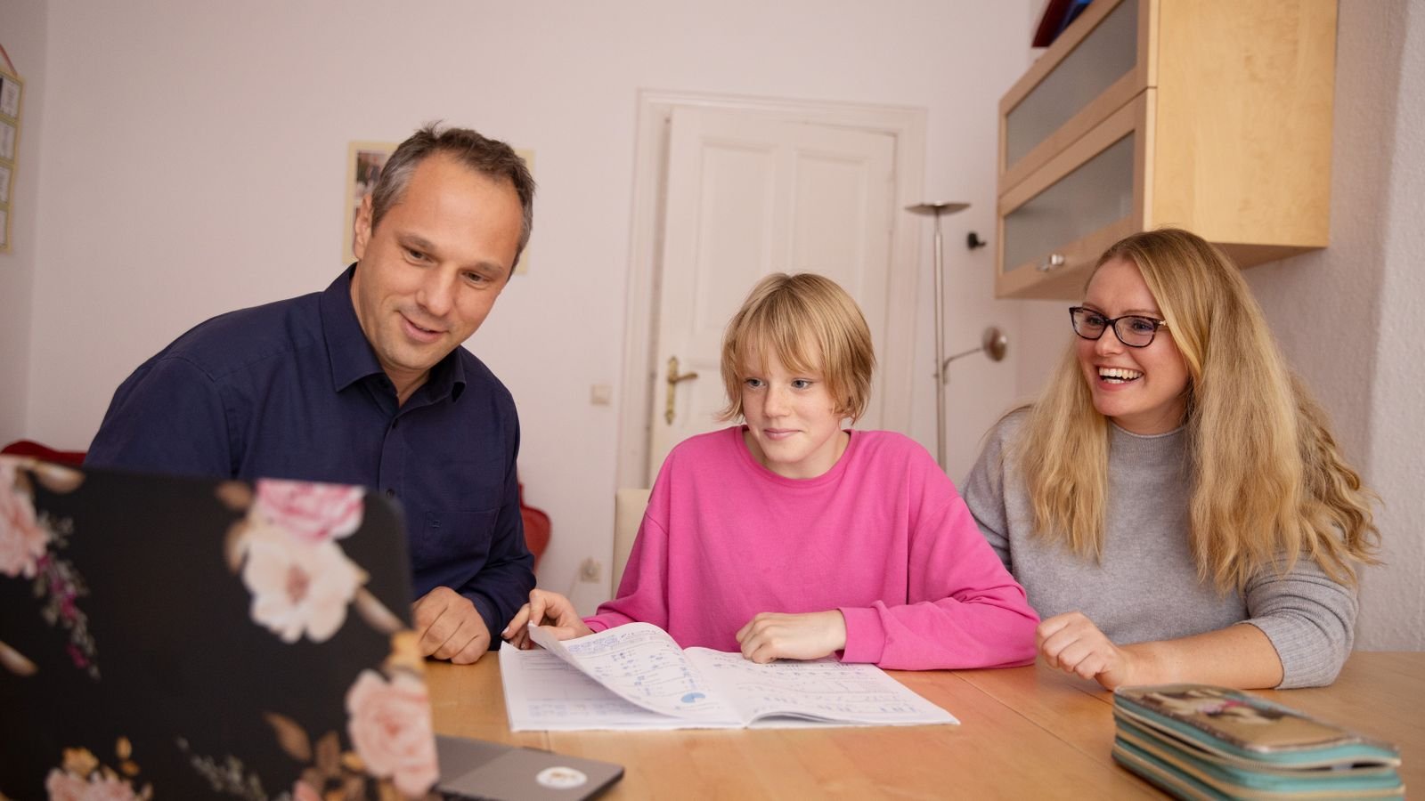 Family using a laptop together at home with guidance and support